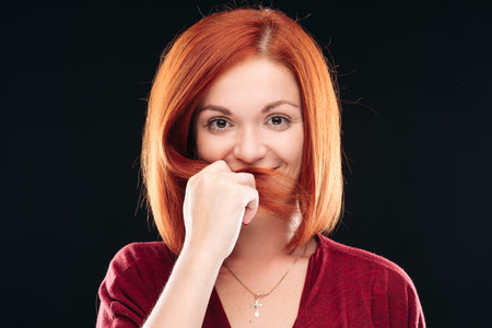 Gorgeous girl having straight ginger hair looking at camera.