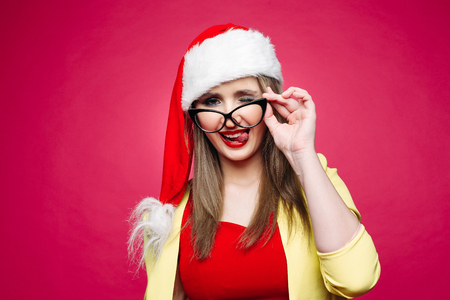 Girl in santa hat and glasses flirting with camera.の写真素材