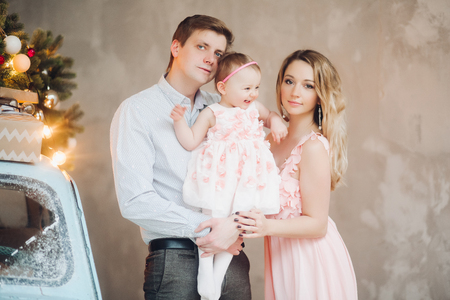 Beautiful family posing together near blue retro Christmas car.の写真素材