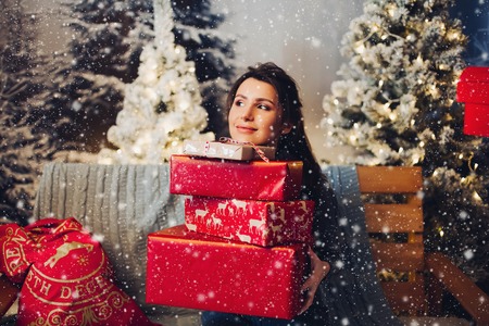 Beautiful woman with pile of Christmas presents.の写真素材