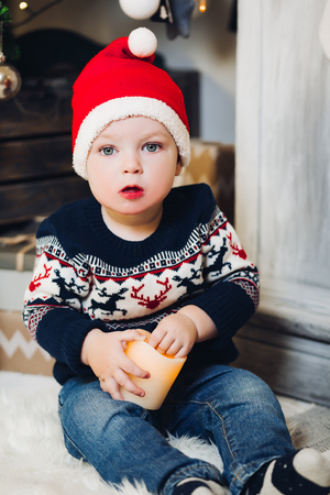 Little blonde boy playing with Christmas presents and boxes.の写真素材