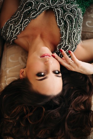 Above view of beautiful brunette woman with perfect volumed hair seductive touching face.の写真素材