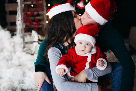 Happy family with adorable kid having fun at Christmas tree.の写真素材