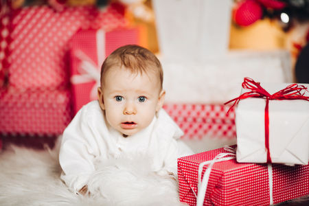 Cute baby in white with christmas presents.の写真素材