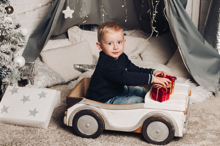 Portrait boy shows Christmas boxes with gifts.の写真素材