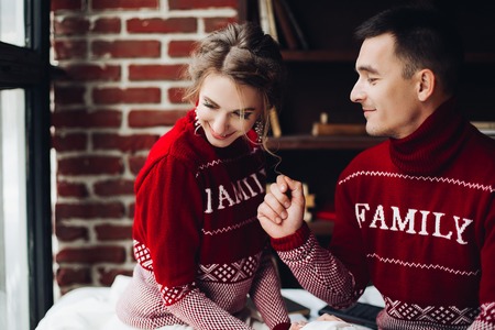 Sensuality couple in red sweaters having fun together, celebrating new year.の写真素材