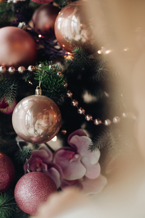 Christmas tree with pink checkered bows and ribbons and festive mood near fire place.の写真素材