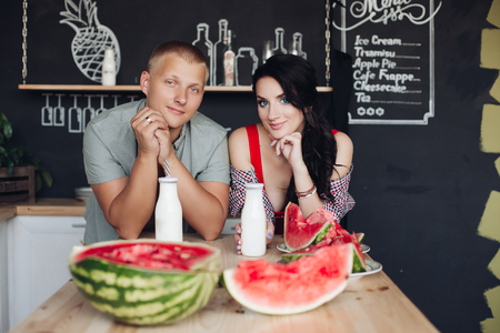 Beautiful pair looking at each other and smiling at kitchenの写真素材