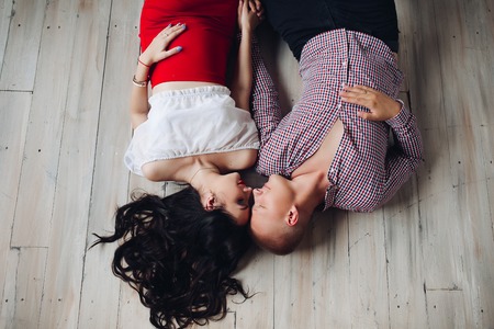 View from above of beautiful pair lying on floorの写真素材