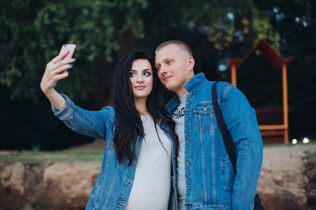 Lovely couple walking in park and taking selfie together