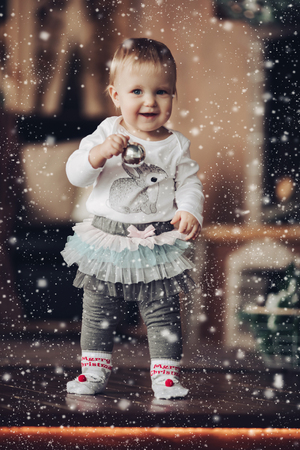 Adorable baby girl with silver Christmas ball.の写真素材