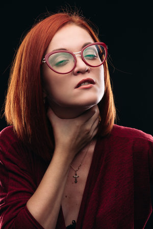 Woman in spectacles having sore throat, she holding hand on neck.
