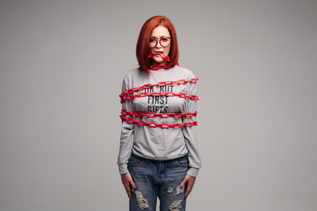girl entangled in a chain,A red-haired woman with brown hair tries to get rid of the chainの写真素材