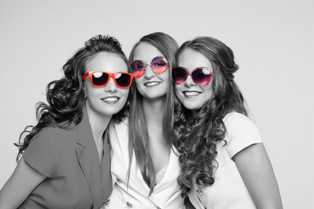 Beautiful happy ladies in fashionable sunglasses and jackets.の写真素材