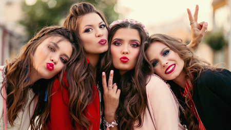 Group of gorgeous girlfriends smiling and gesturing at camera.