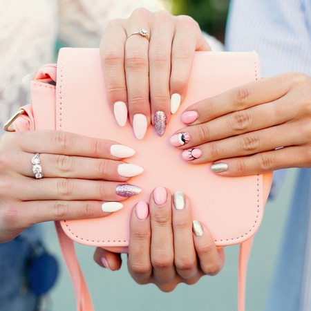 Two girls with design manicure holding leather pink bag.の写真素材