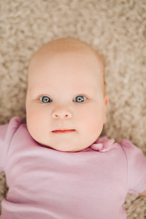 View from above of sweet little girl lying on floor