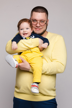 Portrait of happy father posing with lovely smiling child.の写真素材