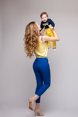 Young and fit woman in casual clothes holding little kid.の写真素材