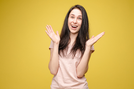 Surprised young girl on yellow isolated background in studioの写真素材