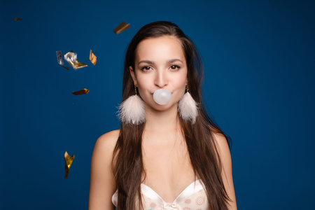 Female teenager chewing gum and keeping balloon
