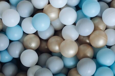 Colorful plastic balls from above. Top view of colorful plastic balls in a pile heap. White, golden, blue, gray colors.の写真素材