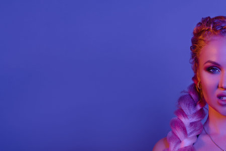 Portrait of seductive young European woman surrounded by evening neon lights medium close-up