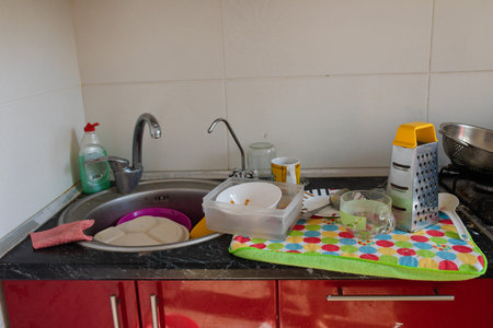 Tableware and dishware drying on towel.Clean dishes and kitchenware drying on a colorful towel near...
