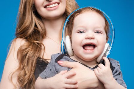 Happy woman with baby boy in headphones.の写真素材