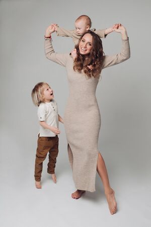 Happy young mother posing at camera together with her kids.の写真素材