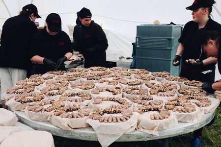 Belaris Minsk 26 07 2019Workers preparing rolls for catering.Employees in black uniform serving aubergine veggie rolls on round platters for special event, wedding, catering, ceremony.のeditorial素材