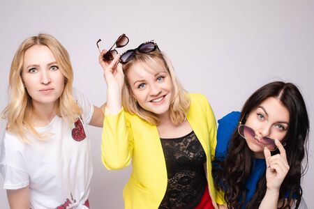Two happy beautiful woman friend celebrating posing surrounded by colorful air balloon confettiの写真素材