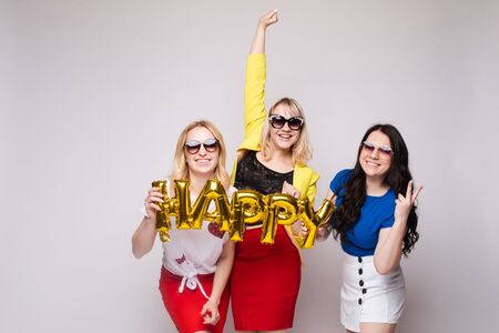 Cheerful women celebrating birthday party and posingの写真素材