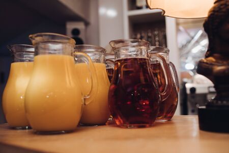 Several jars of fresh orange and berry juice on wooden table. Party concept.の写真素材