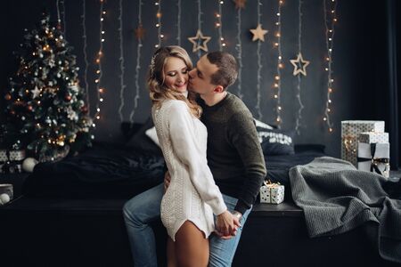 Smiling couple kissing in decorated room for Christmas.の写真素材