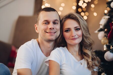 Loving couple against the Christmas tree.の写真素材