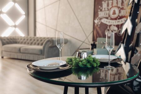 Romantic dinner for two at Christmas. plates against classic sofa in modern apartment.の写真素材