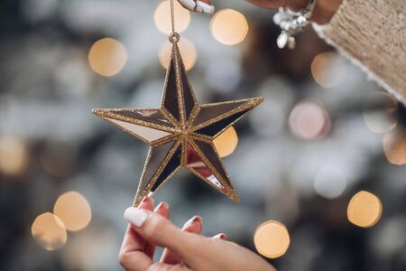Close up of woman with toy glass decorative star in hands. New Year eve conceptの写真素材