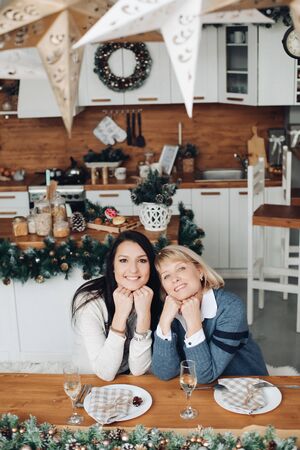 Happy mother and daughter staying together in the kitchenの写真素材