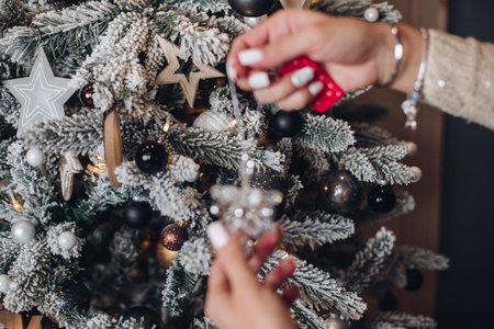 Woman placing Christmas toy on the tree