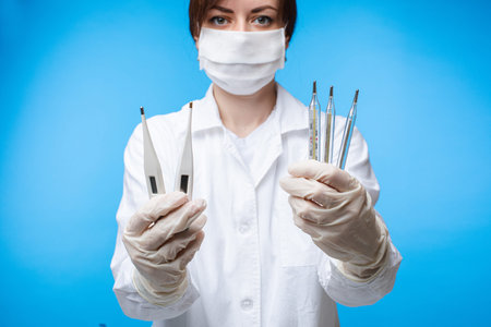 Beautiful caucasian woman with special medical mask do an experiment with thermometers, portrait...