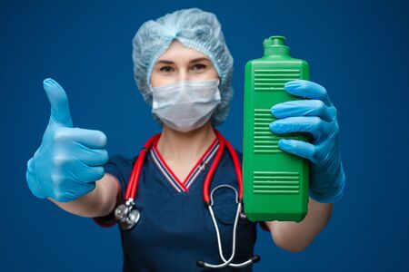 Nurse or doctor with a bottle of sanitizer and thumb up.の写真素材