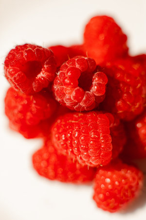 A picture of a few raspberries lies on a white background. Background and picture for postcard