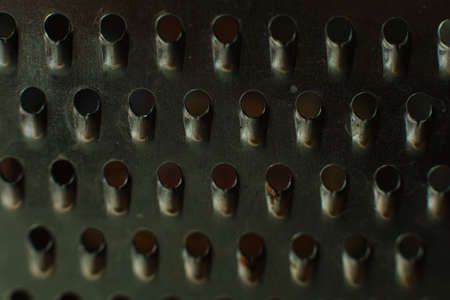 Ordinary metal kitchen grater with oval holes on it, picture backgroundの写真素材