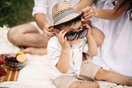 Picture of cheerful young caucasian female and male holds their child on hands, smiles and rejoicesの写真素材