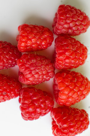Collected raspberries on white background. Concept of love. Juicy raspberries dessert.