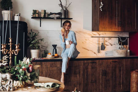 Beautiful woman having fun at breakfast. Christmas morningの写真素材