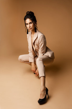 beautiful female fashion model with dark hair in suit poses for the cameraの写真素材