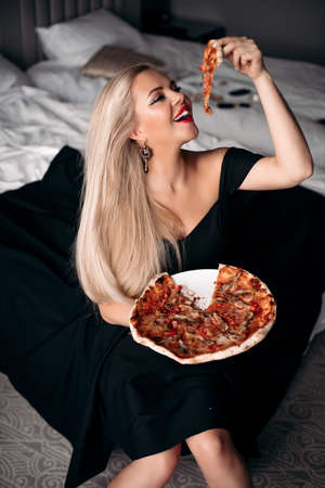 Happy beautiful lady are going to tasting pizza in roomの写真素材