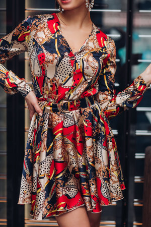 Crop of fashionable woman wearing silk dress.